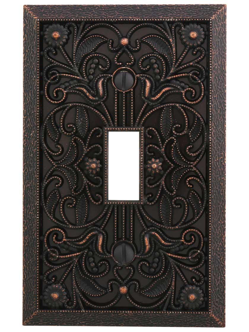 Filigree Single-Toggle Switch Plate in Aged Bronze.